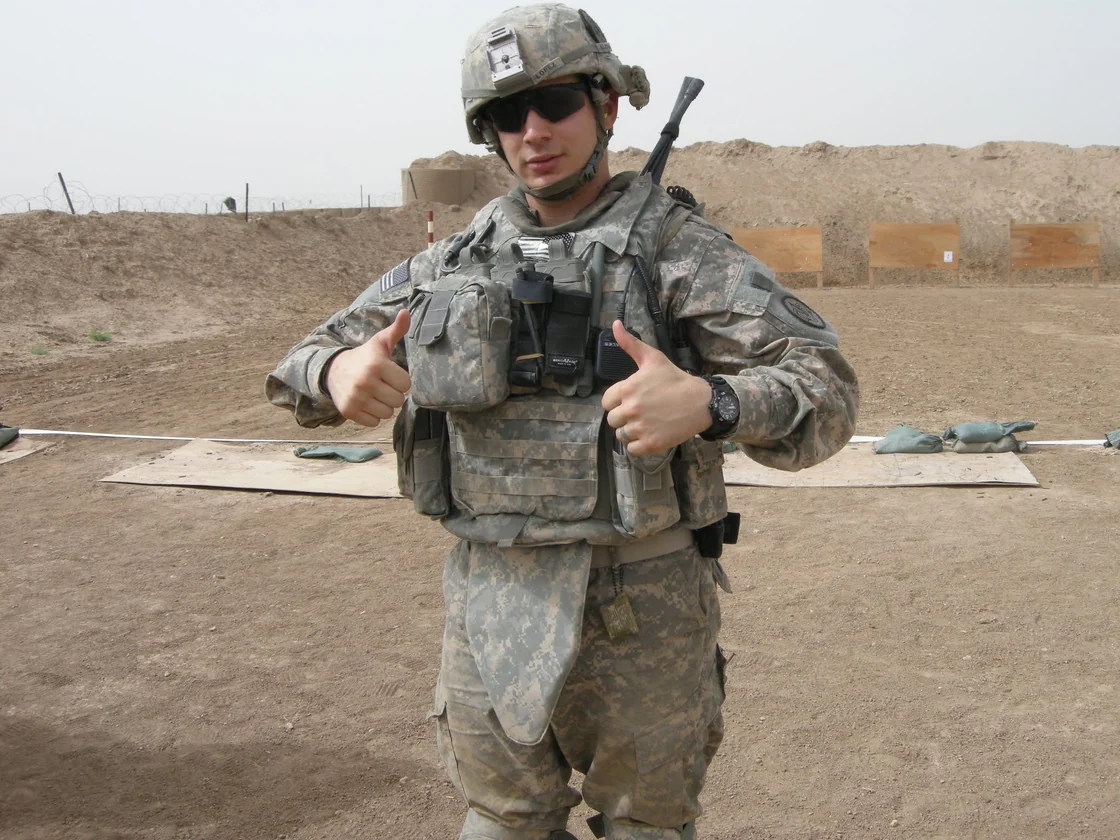 Ariel Lopez in Army uniform and helmet, giving two thumbs up.