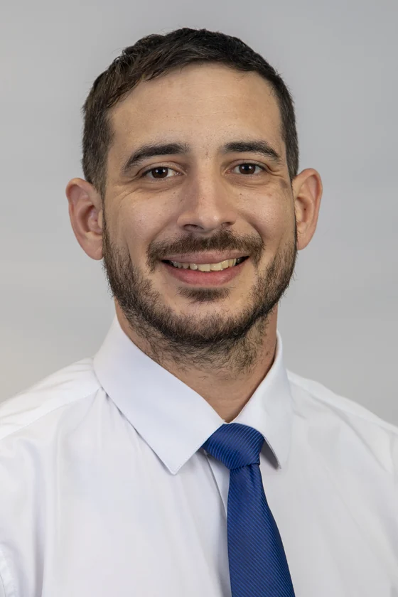 Ariel Lopez wearing a white dress shirt and blue tie.